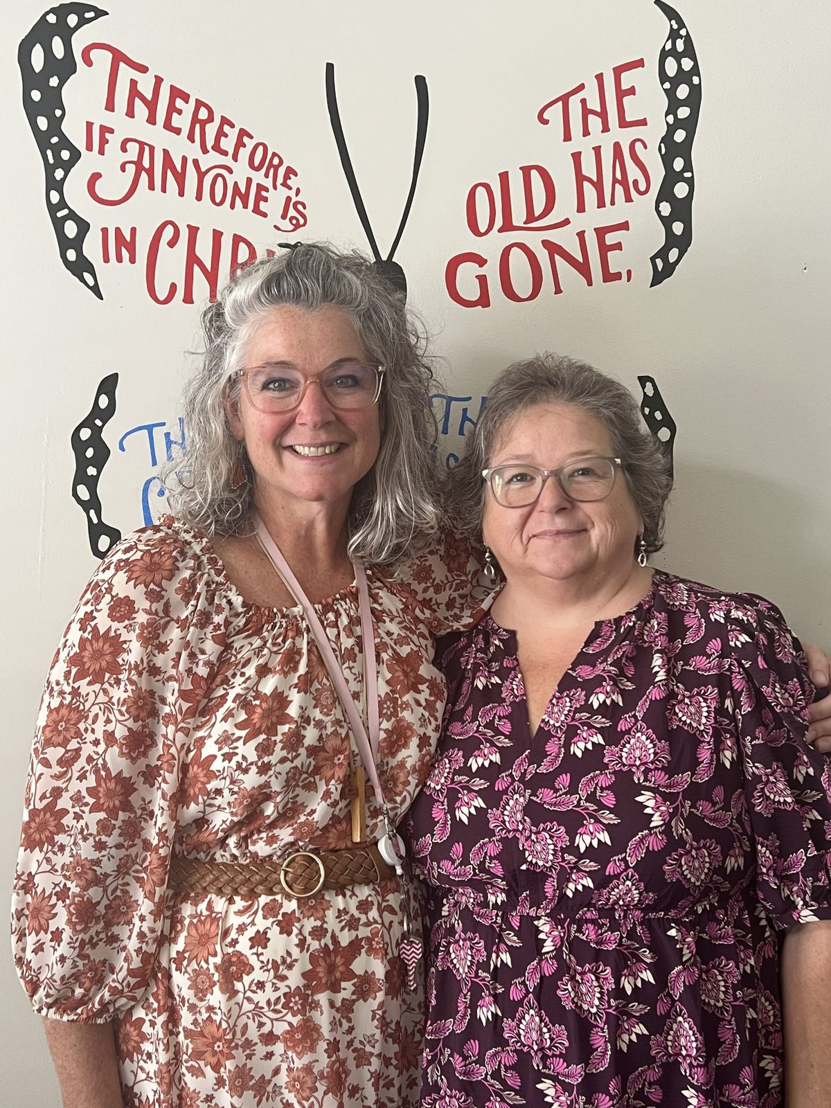 Stacy Waldroop and Tonya Hunt in front of the LifeWorks butterfly mural — “Therefore, if anyone is in Christ… the old has gone”