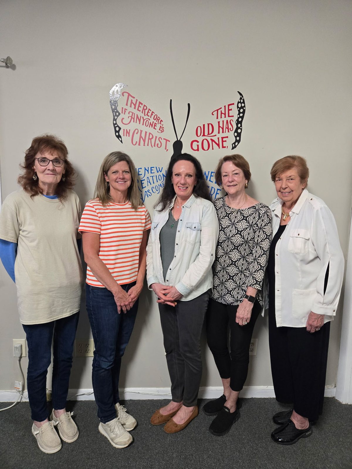 The LifeWorks Board of Directors standing before the butterfly mural